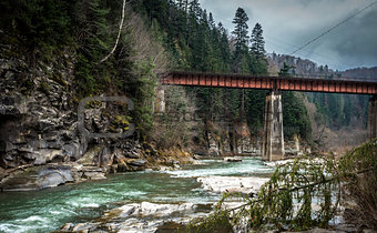 landscape in Carpathian mountains with river and railway bridge