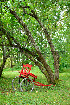 Red cart next to leaning trees