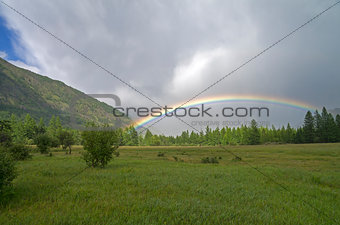 Rainbow in a mountain valley.