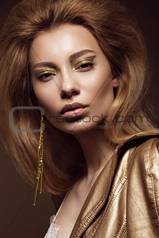 Beautiful girl in a gold dress with creative makeup and hair. The beauty of the face.