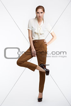 Young attractive slim fashion model posing on gray background