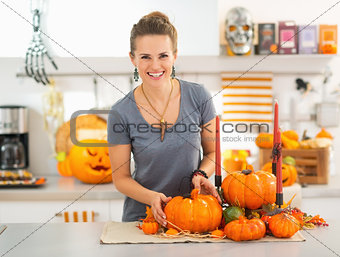 Smiling young woman decorating kitchen for halloween
