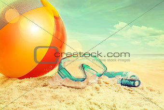 Beach ball and goggles in the sand