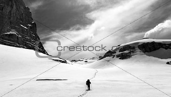 Hiker on snow plateau. Black and white panoramic view.