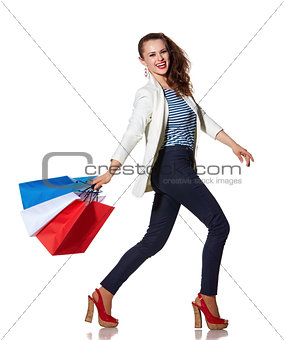 Smiling woman walking with French flag colours shopping bags