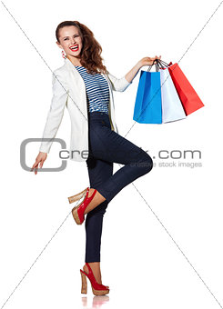 Happy young woman with shopping bags posing on white background
