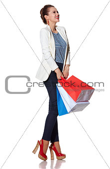 Woman with shopping bags on white background looking aside