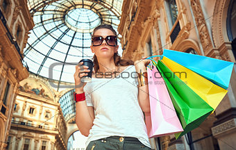 Fashion woman with shopping bags and coffee cup in Galleria