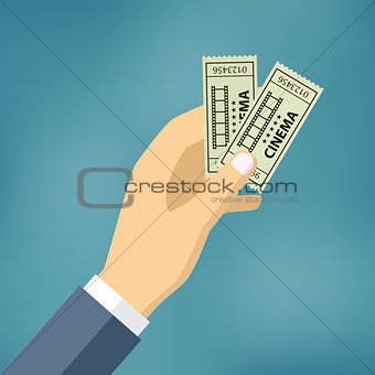 Hand with two cinema tickets.