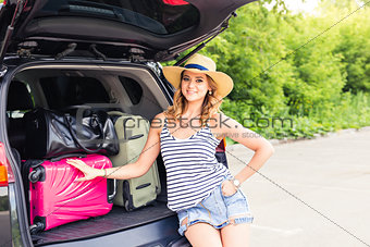 Vacation, Travel concept - young woman ready for the journey on summer holidays with suitcases and car