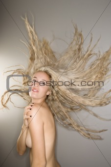 Nude woman with blowing hair.