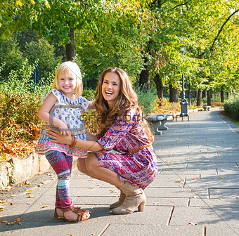 Full length portrait of happy mother and daughter at the park.