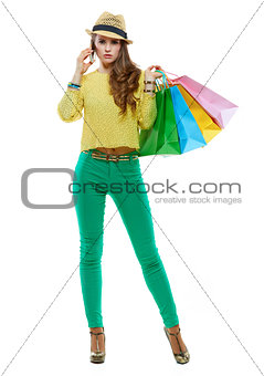 Woman with shopping bags talking smartphone on white background