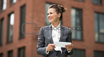 Modern business woman with tablet PC looking aside