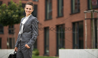 Portrait of business woman with briefcase near office building