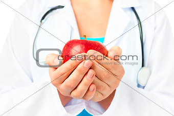 hands of the doctor with a red apple close up