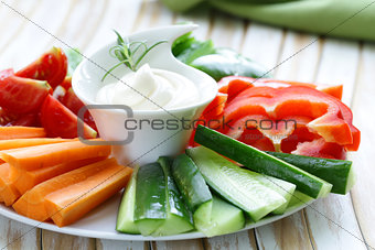 fresh vegetables snack - carrots, sweet pepper, cucumbers and tomatoes with dip