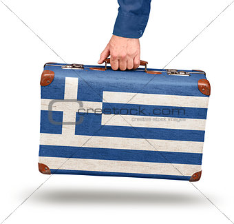 Male hand holding vintage Greek flag suitcase
