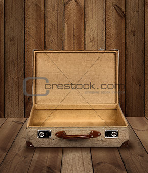 Empty vintage suitcase wooden plank background