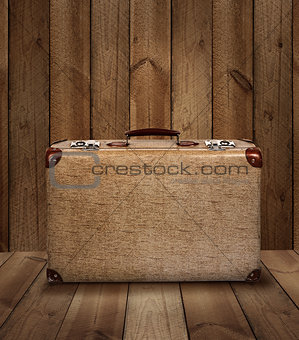 Vintage suitcase on wooden plank background