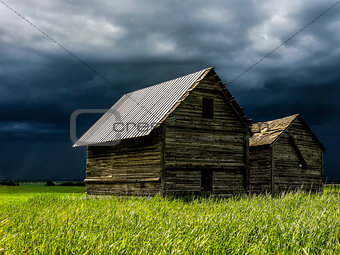 Sunny old barn in front of a storm