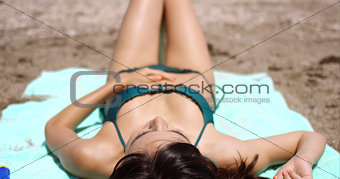 Woman suntanning on a tropical beach in summer sun