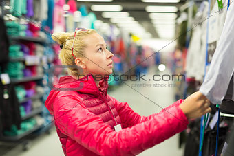 Woman shopping sportswear in sports store.