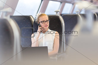 Business woman working while travelling by train.