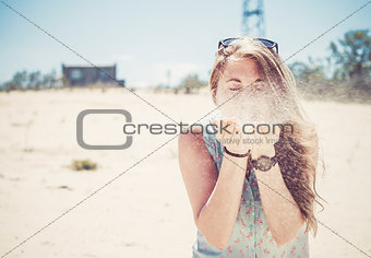 Girl blowing sand