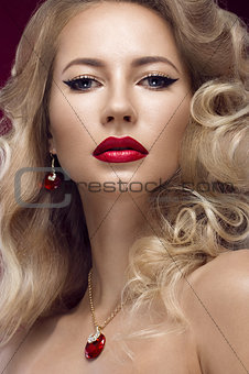 Beautiful blonde in a Hollywood manner with curls, red lips. Beauty face.