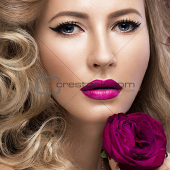 Beautiful blonde in a Hollywood manner with curls, pink lips. Beauty face.
