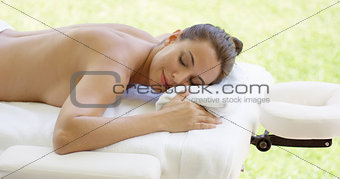 Disrobed woman lays belly down on table