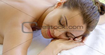 Woman with chin on folded towel smiles