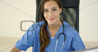 Young female physician places one hand on her face
