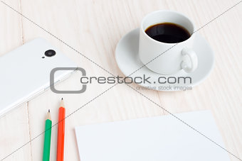 Cup of coffee, a Notepad, pencils, a smartphone on the table