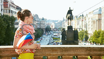 Woman with Czech flag standing near National Museum in Prague