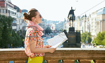 Smiling woman with map standing near National Museum in Prague