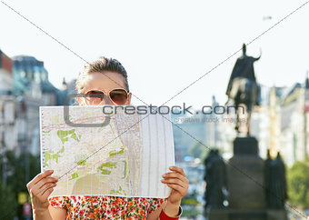 Woman hiding behind map while standing at Wenceslas Square