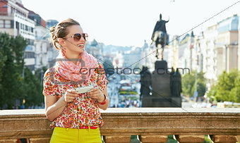 Woman with smartphone standing near National Museum in Prague
