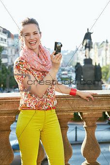Happy woman taking photos with digital camera in Prague