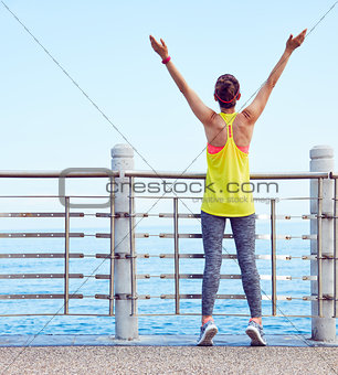 Relaxed young healthy woman rejoicing at embankment