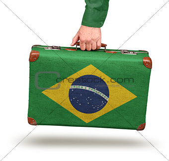 Male hand holding vintage Brazilian flag suitcase