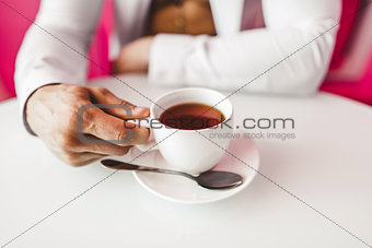 Man with white cup in the kitchen