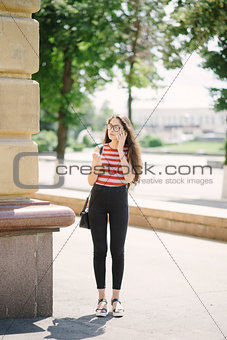 Young Asian woman with glasses hold smartphone in hands.