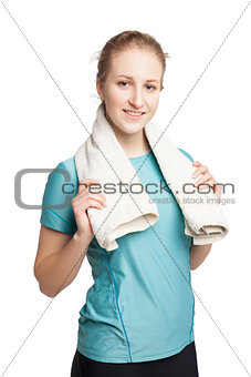 Smiling happy female fitness model with a towel looking at camera