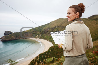 Happy woman hiker with map looking into the distance