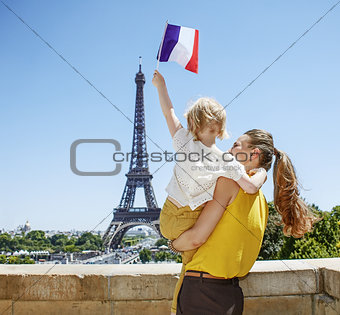 mother and child travellers rising flag in Paris, France