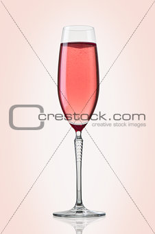 Glass of pink champagne on pink background