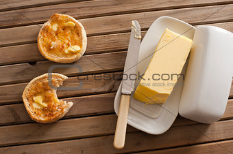 Stick of butter besides two english muffins