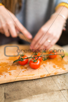 the girl cuts cherry tomatoes.